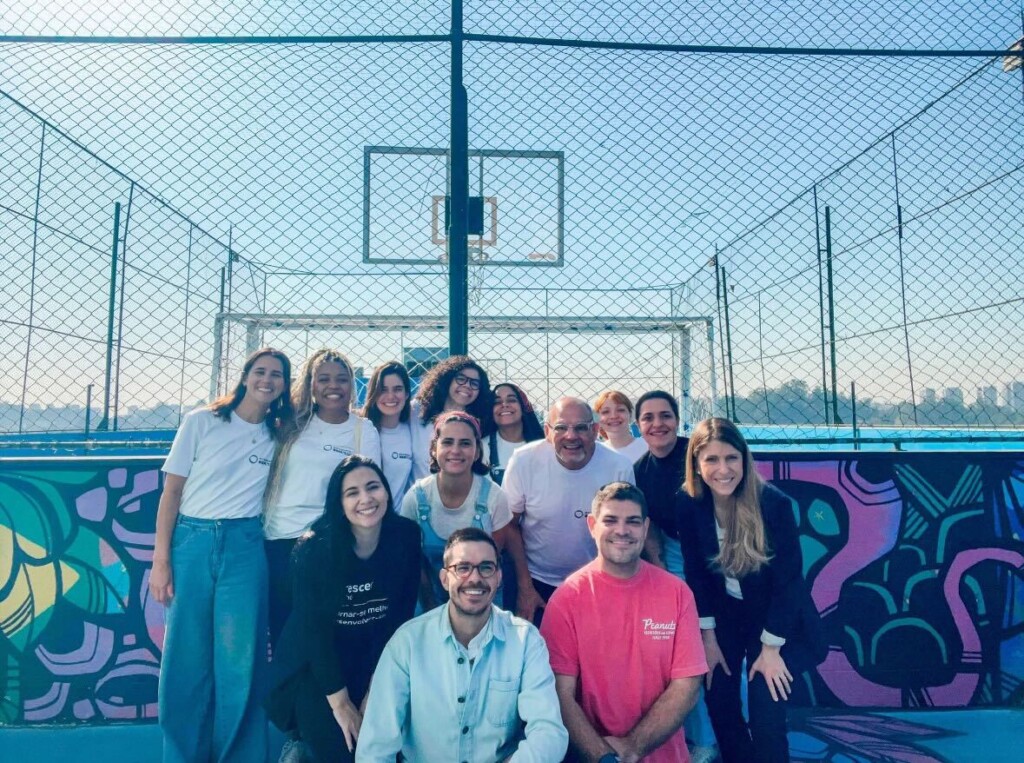Equipe do Movimento Bem Maior e da Crescer Sempre reunida na quadra da escola em Paraisópolis, durante visita institucional para conhecer as iniciativas de educação e inclusão da organização.